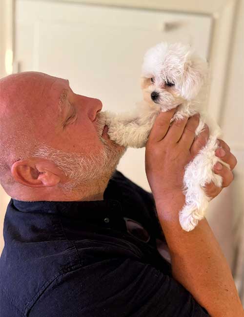 Man som håller i en valp